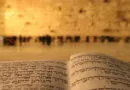 Bíblia em hebraico aberta e muro das lamentações ao fundo
