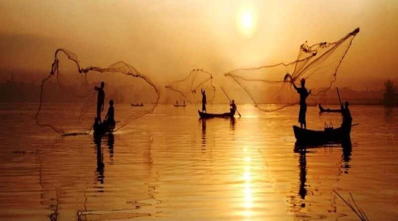 pescadores em canoas lançando rede no rio