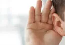 mão posta atrás da orelha