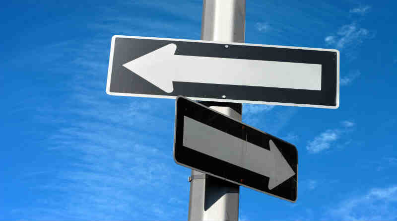 duas placas de trânsito apontando caminhos contrários